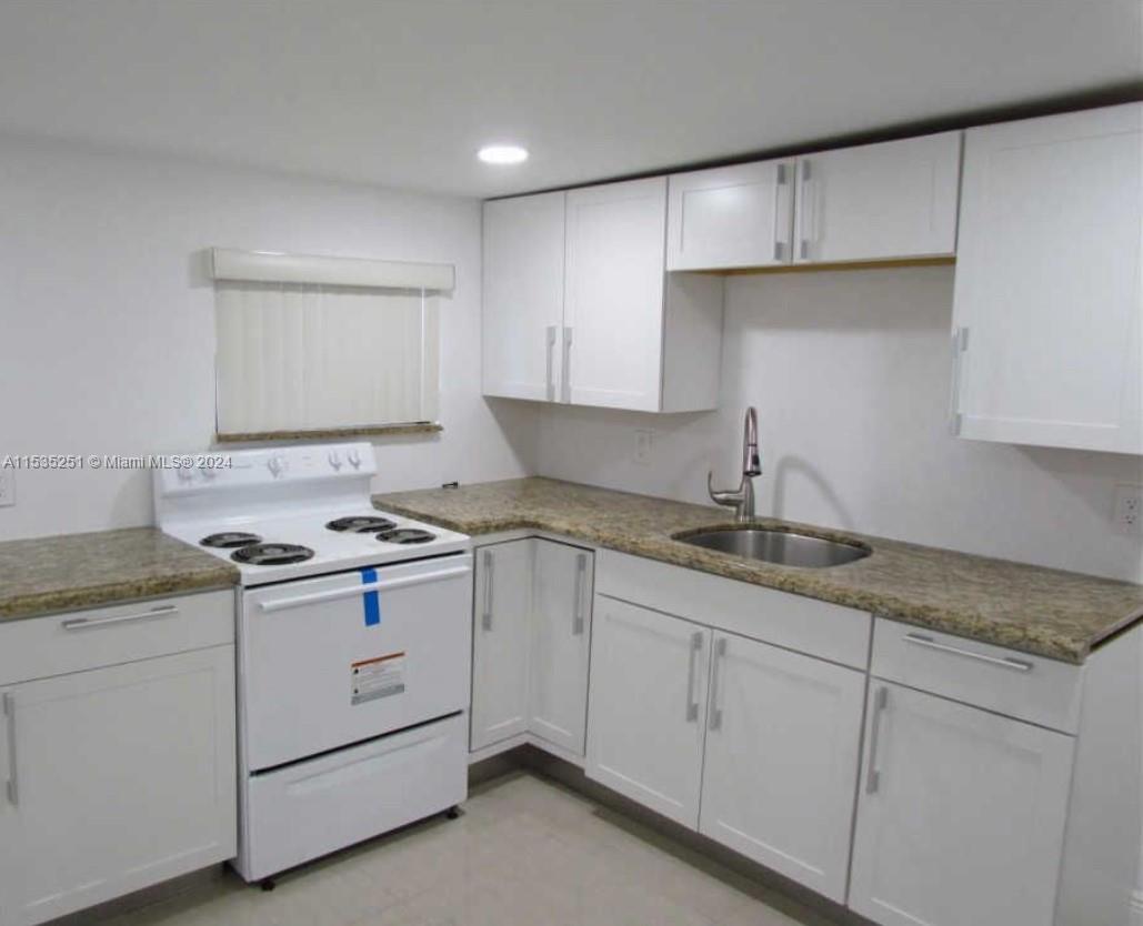 6111 Southwest 39th Street Miramar, FL 33023 - Photo 3 of 8 a kitchen with granite countertop white cabinets and white appliances