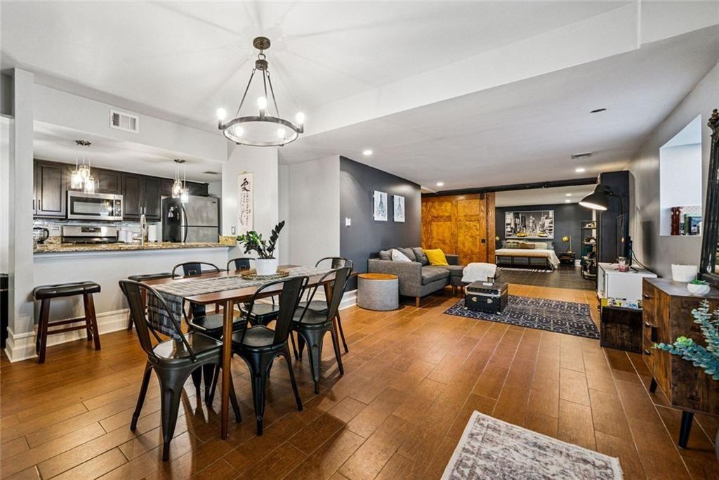 a view of a dining room and livingroom with furniture wooden floor a chandelier