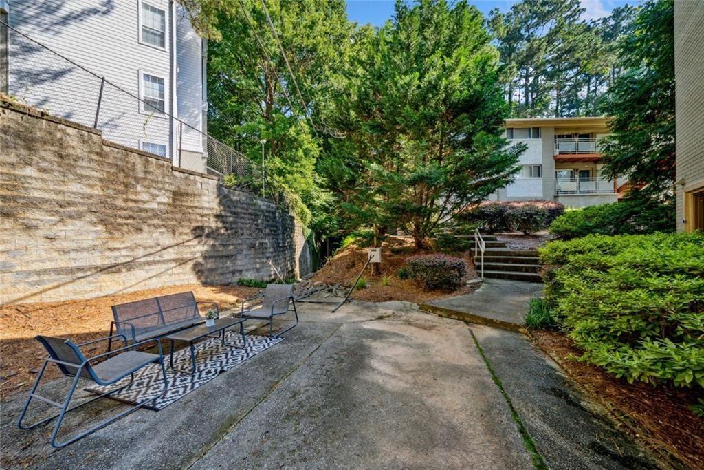 3048 Briarcliff Road Northeast, Unit 9 Atlanta, GA 30329 - Photo 25 of 30 a backyard of a house with table and chairs large trees
