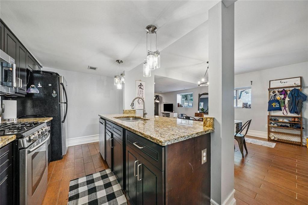 3048 Briarcliff Road Northeast, Unit 9 Atlanta, GA 30329 - Photo 6 of 30 a kitchen with stainless steel appliances granite countertop a stove and a wooden floors