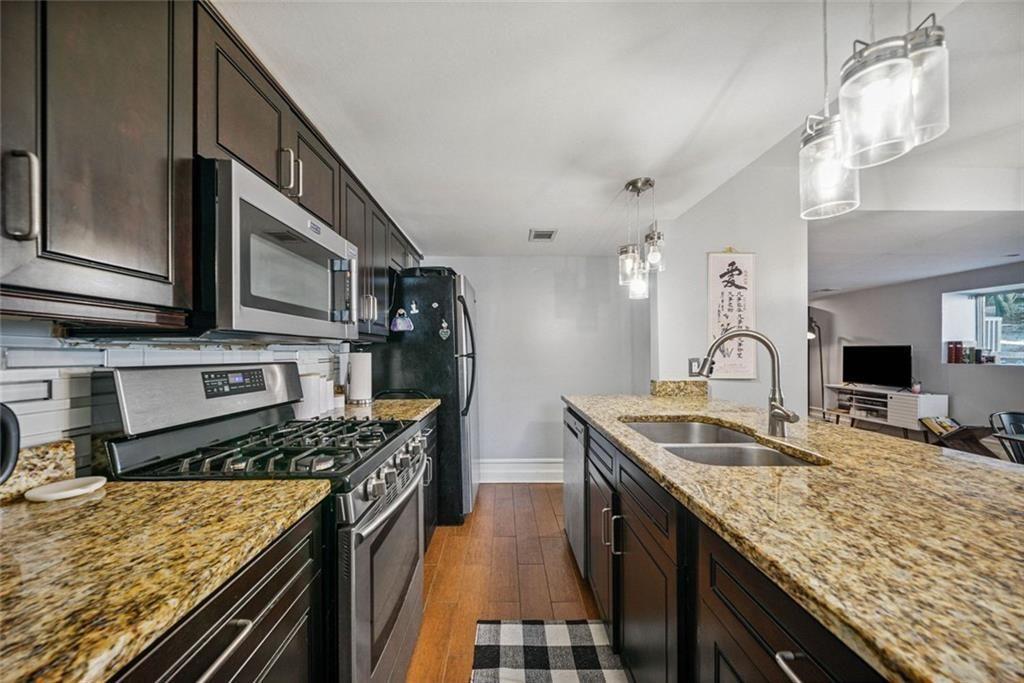 3048 Briarcliff Road Northeast, Unit 9 Atlanta, GA 30329 - Photo 7 of 30 a kitchen with stainless steel appliances granite countertop a sink stove and refrigerator