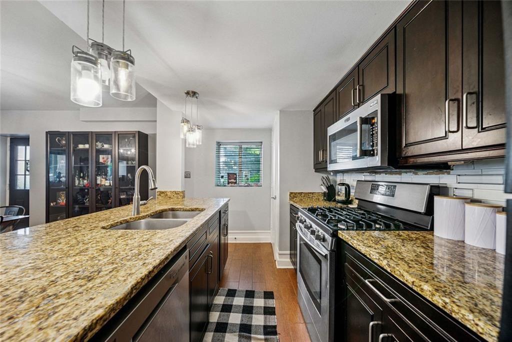 3048 Briarcliff Road Northeast, Unit 9 Atlanta, GA 30329 - Photo 9 of 30 a kitchen with granite countertop stainless steel appliances and wooden cabinets
