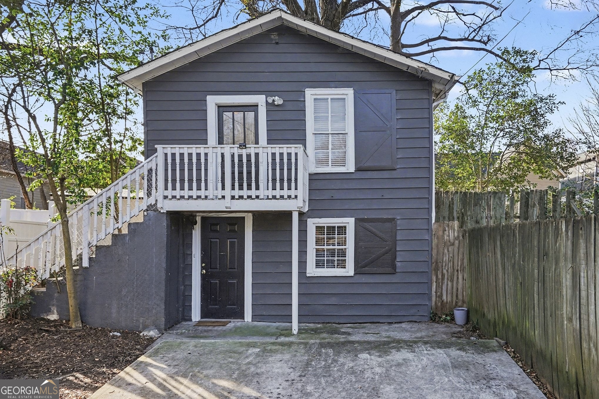 a view of a house with a small yard and wooden fence