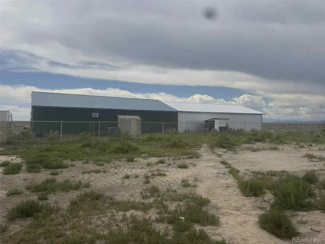 a view of a big yard with plants and large trees