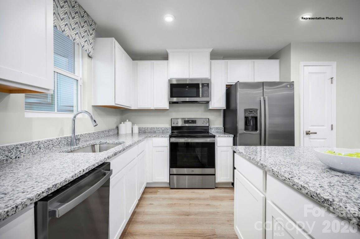 162 Basildon Street, Unit 1064 Lancaster, SC 29720 - Photo 2 of 10 a kitchen with stainless steel appliances granite countertop a sink stove microwave and refrigerator