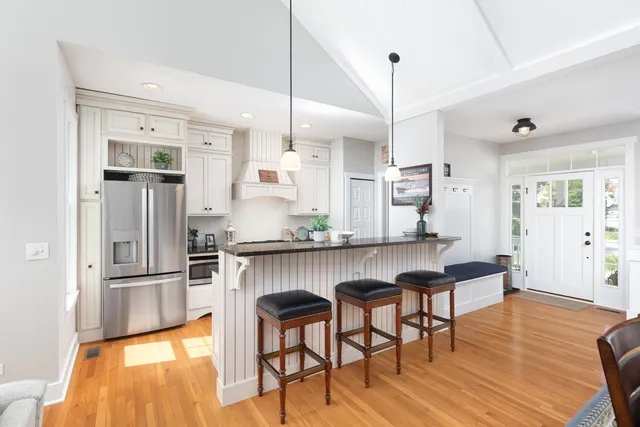 a kitchen with stainless steel appliances granite countertop a kitchen island hardwood floor and a sink