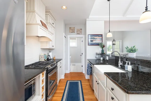 a kitchen with stainless steel appliances granite countertop a sink stove and cabinets