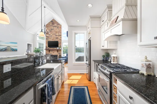 a kitchen with stainless steel appliances granite countertop a stove a sink and a microwave