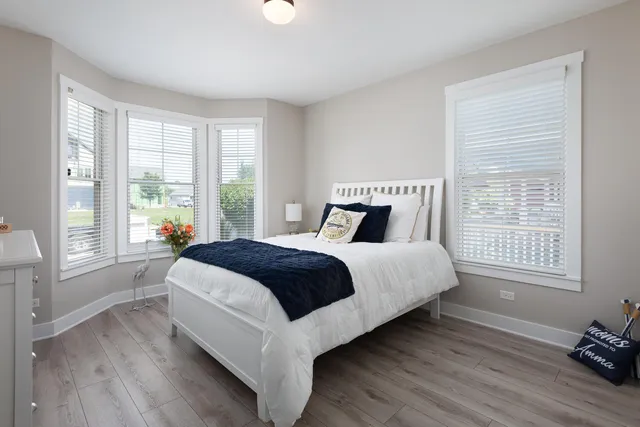 a bedroom with a large bed and wooden floor