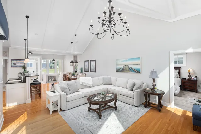 a living room with furniture a chandelier and a rug
