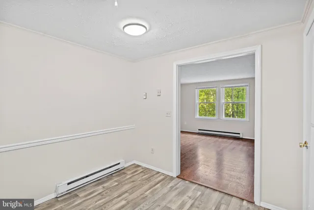 a view of an empty room with closet and a window