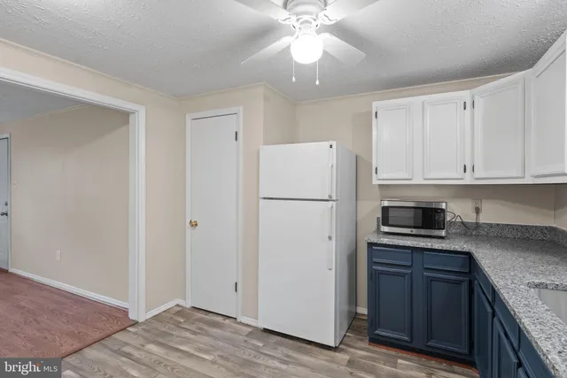a kitchen with a refrigerator a stove top oven and cabinets