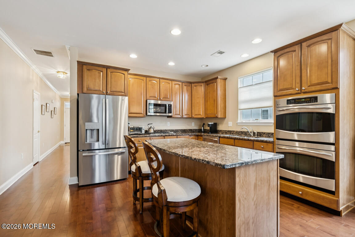 101 Nottingham Way Jackson, NJ 08527 - Photo 7 of 31 a kitchen with stainless steel appliances granite countertop a refrigerator a stove a sink a dining table and chairs with wooden floor