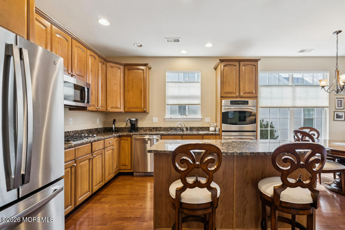 101 Nottingham Way Jackson, NJ 08527 - Photo 8 of 31 a kitchen with stainless steel appliances granite countertop a stove a sink dishwasher and a refrigerator with wooden cabinets
