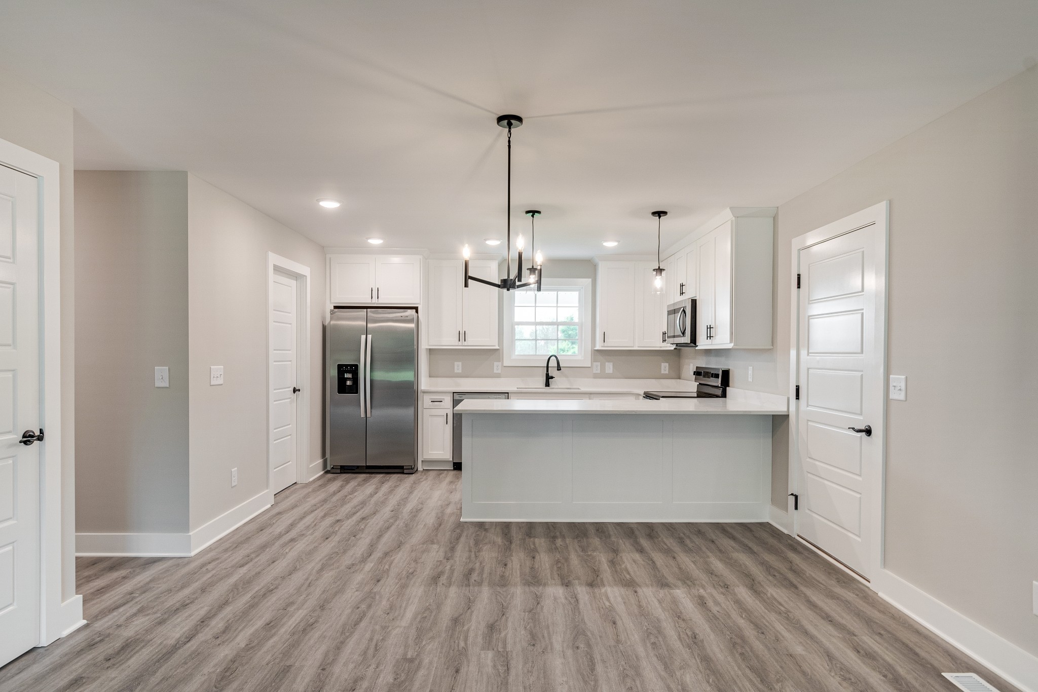 916 Butler Bridge Road Portland, TN 37148 - Photo 9 of 26 a kitchen with stainless steel appliances kitchen island wooden floors and white cabinets