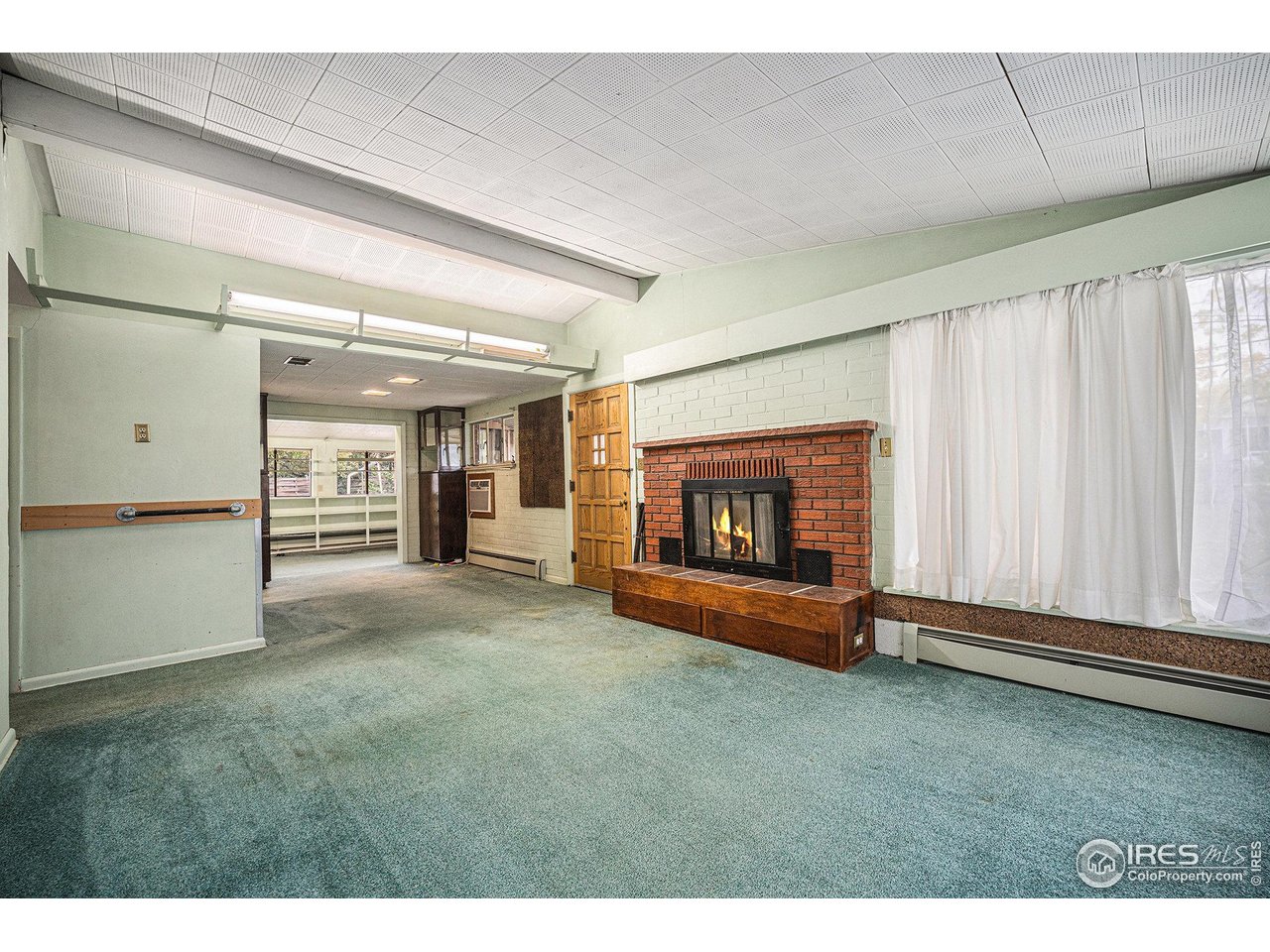 6137 Baseline Road Boulder, CO 80303 - Photo 10 of 40 a view of an empty room with a fireplace and a window