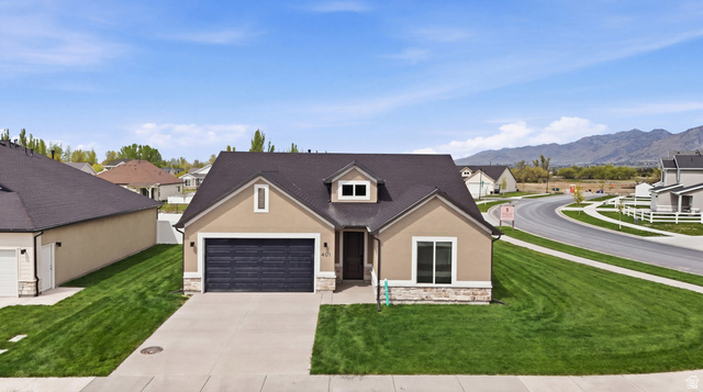 401 West 3085 South, Unit 329 Nibley, UT 84321 - Photo 3 of 34 View of front facade with a front yard, concrete driveway, stucco siding, stone siding, and a garage
