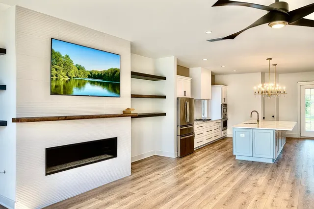 a kitchen with stainless steel appliances kitchen island granite countertop a stove a sink and a wooden floors