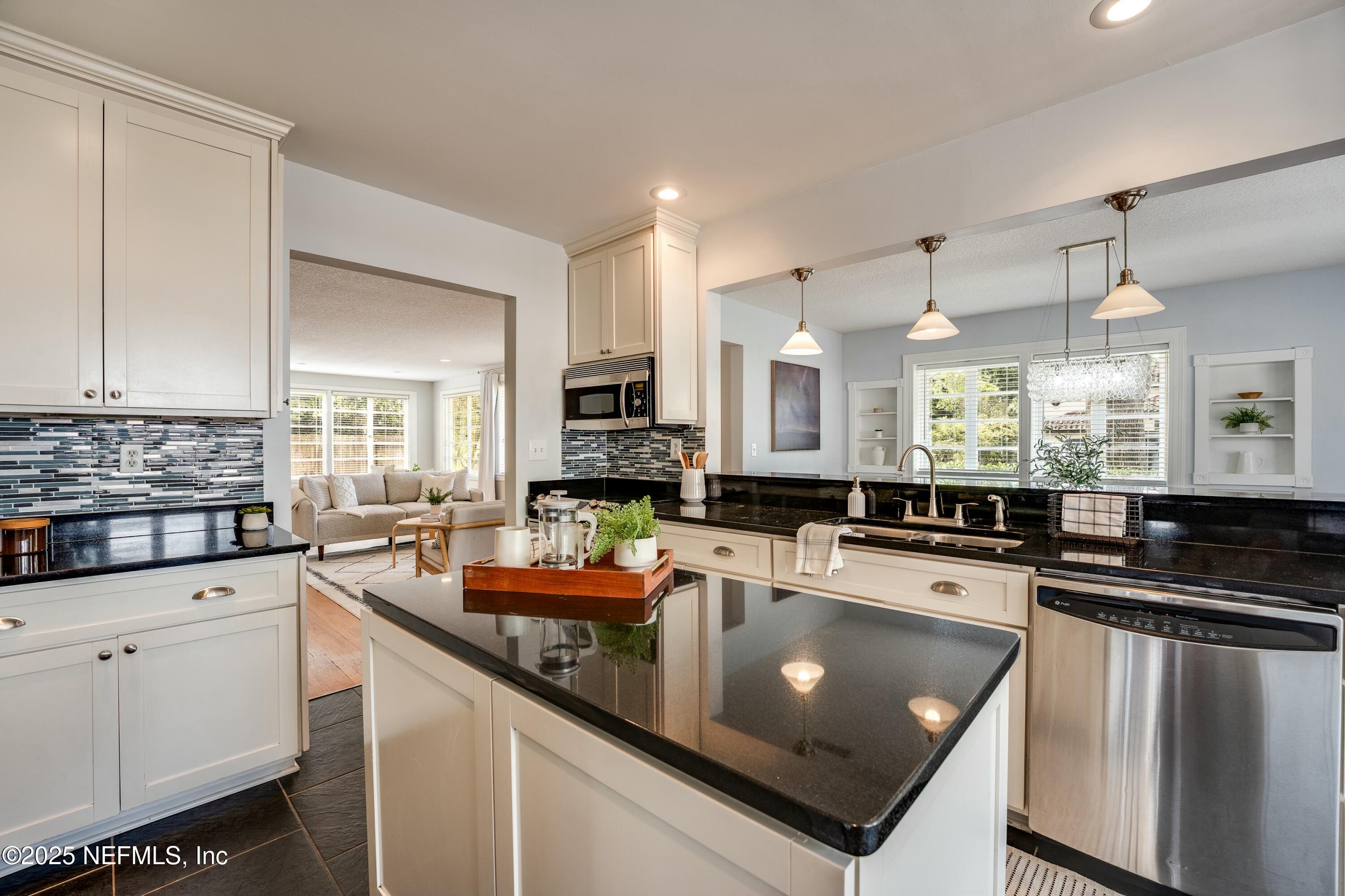 1235 Morvenwood Road Jacksonville, FL 32207 - Photo 21 of 55 a kitchen with stainless steel appliances a sink a stove a refrigerator cabinets and living room view