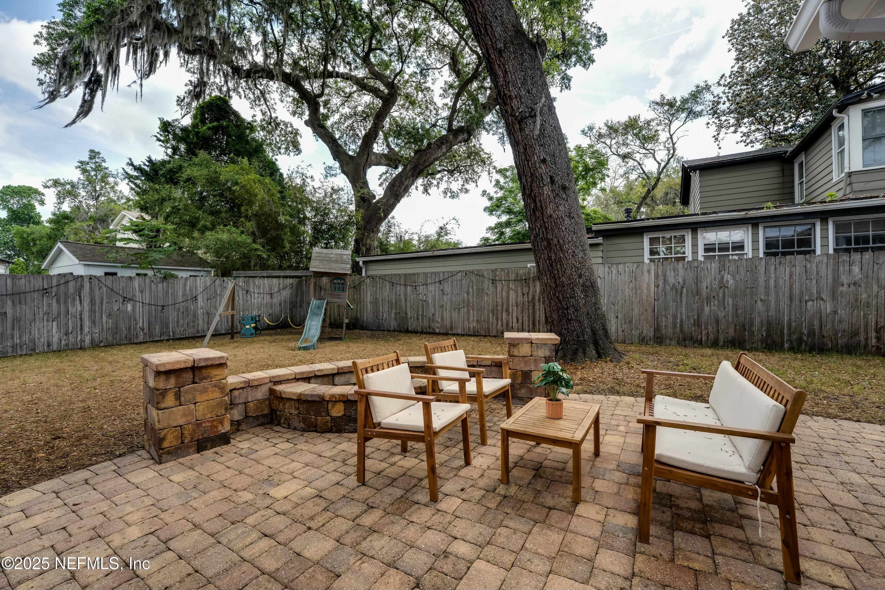 1235 Morvenwood Road Jacksonville, FL 32207 - Photo 35 of 55 a backyard of a house with fountain table and chairs