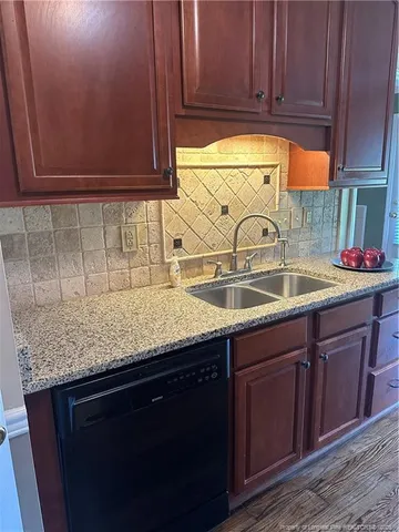 an empty room with wooden floor mirror and windows