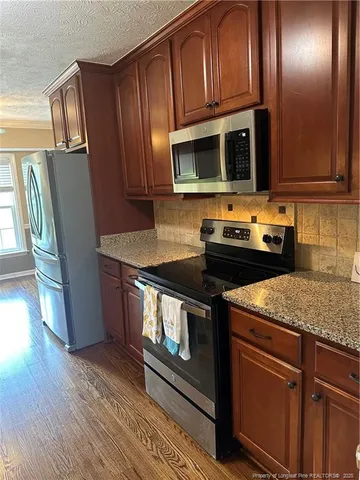 a kitchen with granite countertop stainless steel appliances sink and cabinets