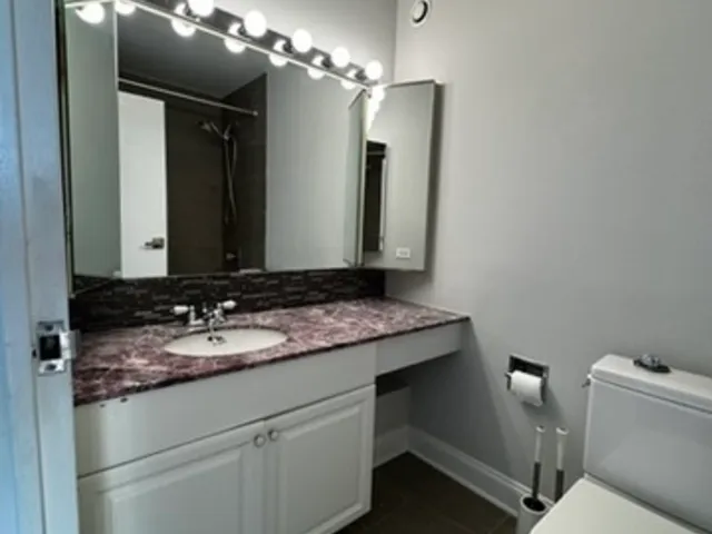 a bathroom with a granite countertop sink and a mirror