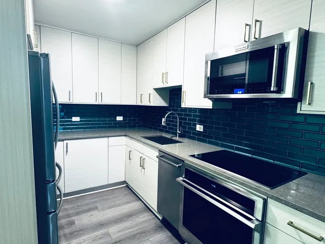 a kitchen with stainless steel appliances granite countertop a sink stove and microwave