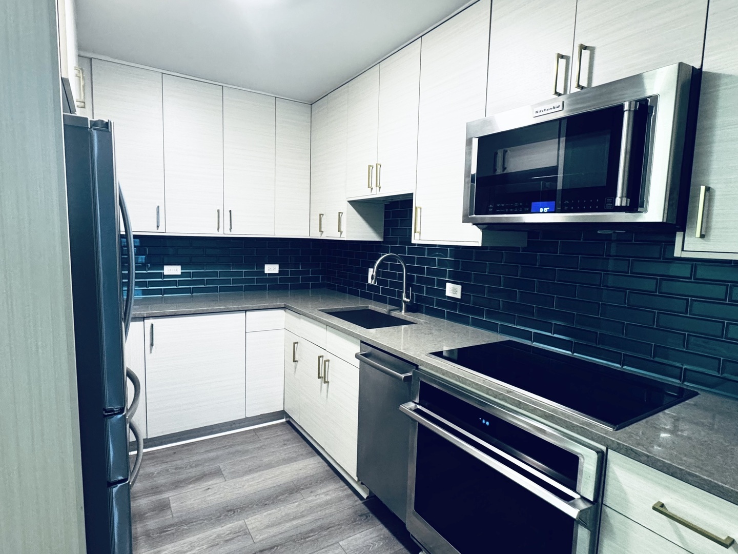 5320 North Sheridan Road, Unit 2109 Chicago, IL 60640 - Photo 4 of 16 a kitchen with stainless steel appliances granite countertop a sink stove and microwave