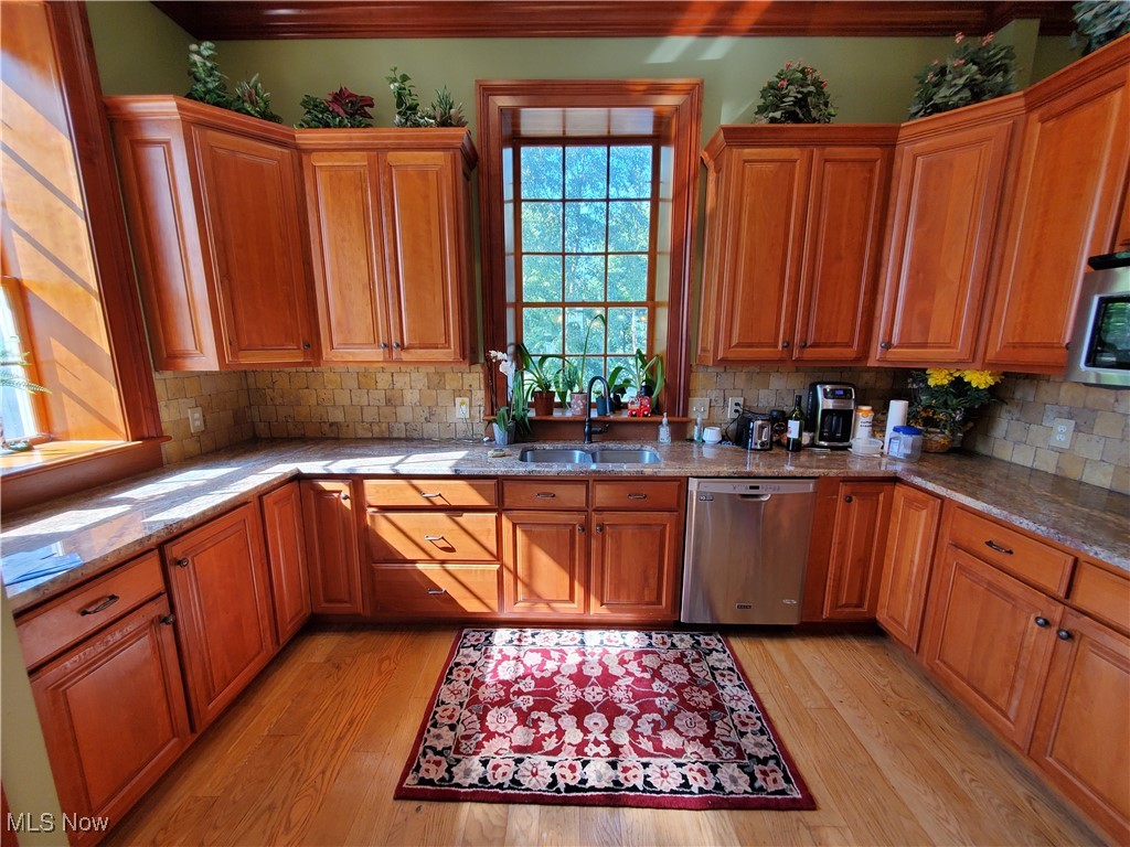 150 Main Street Hayesville, OH 44805 - Photo 12 of 50 Kitchen featuring light stone counters, dishwasher, cabinets, and light wood-style flooring.
