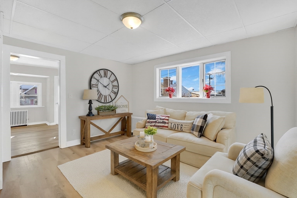 12 Stebbins Street Chicopee, MA 01020 - Photo 14 of 39 a living room with furniture a rug and a wall painting