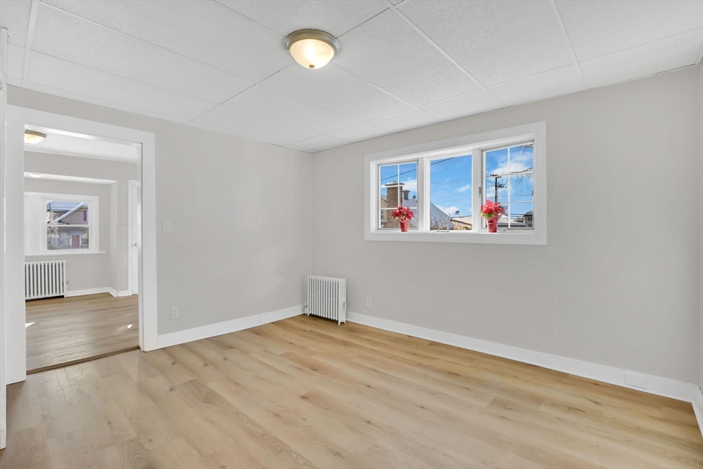 12 Stebbins Street Chicopee, MA 01020 - Photo 15 of 39 an empty room with wooden floor and windows