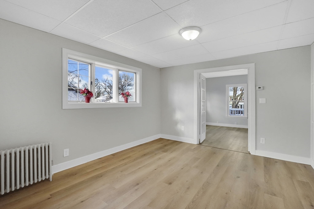12 Stebbins Street Chicopee, MA 01020 - Photo 16 of 39 wooden floor in an empty room with a window