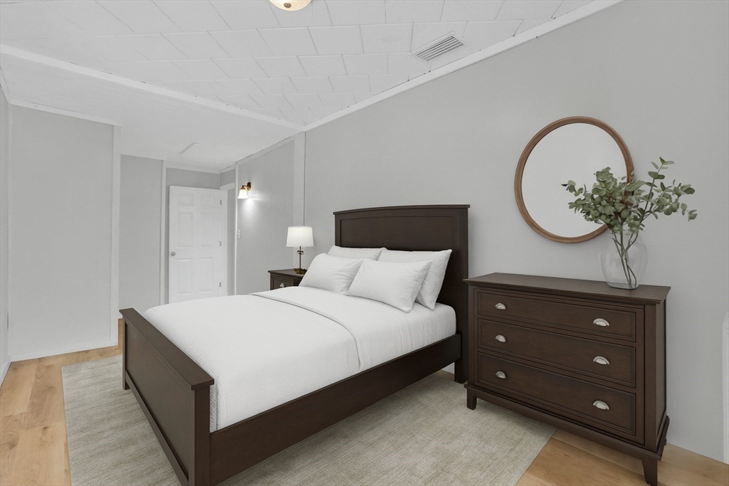 12 Stebbins Street Chicopee, MA 01020 - Photo 19 of 39 a spacious bedroom with a bed and a potted plant