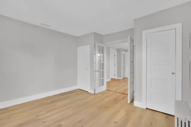 a view of empty room with wooden floor