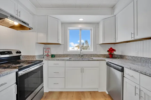 a kitchen with granite countertop white cabinets and white appliances