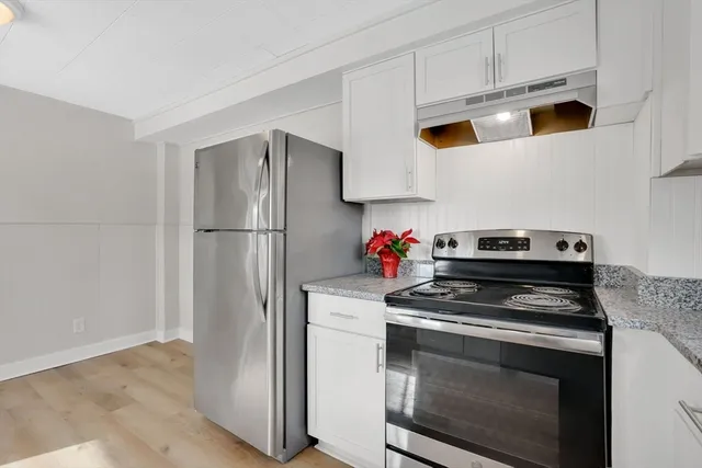 a kitchen with stainless steel appliances white cabinets and a stove