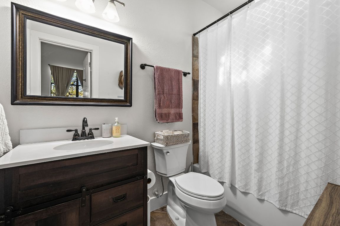 907 Duncan Lane, Unit 302 Austin, TX 78705 - Photo 14 of 24 a bathroom with a toilet a sink and a mirror