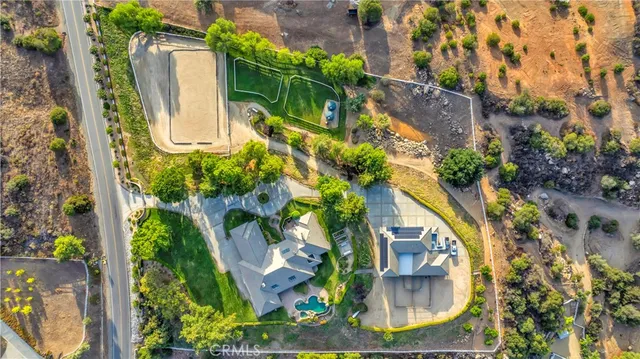 an aerial view of a house with garden space and a lake view