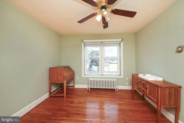 a view of a livingroom with wooden floor and a ceiling fan