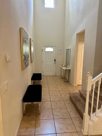 a view of a hallway to a livingroom with wooden floor and furniture