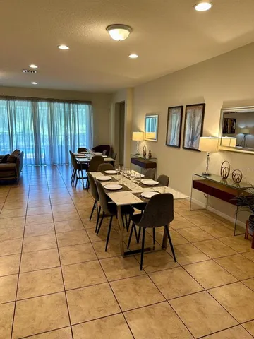 a living room with patio furniture and a wooden floor