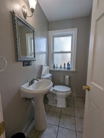 a bathroom with a toilet a sink and mirror