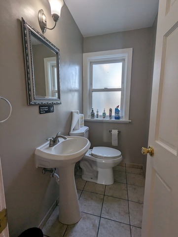 6950 Dempster Street Morton Grove, IL 60053 - Photo 13 of 21 a bathroom with a toilet a sink and mirror
