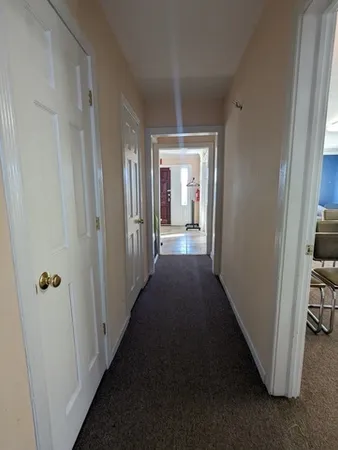 a view of a hallway with a livingroom and furniture