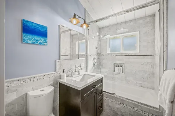 a bathroom with a sink a toilet and shower
