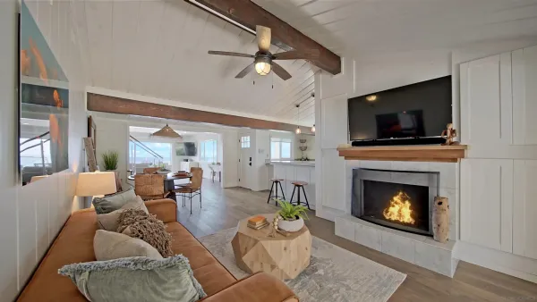 a living room with furniture a flat screen tv and a fireplace