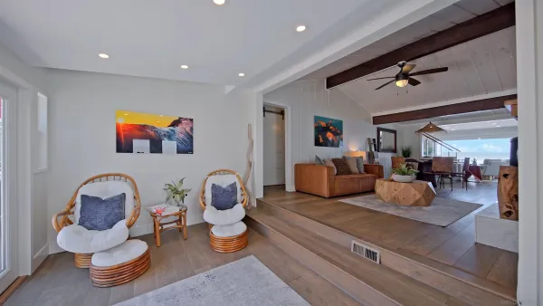 a living room with furniture chess board and a ceiling fan