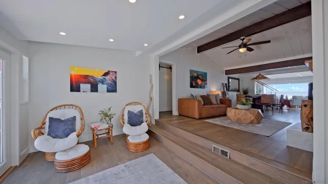 a living room with furniture chess board and a ceiling fan