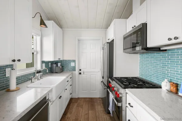 a kitchen with a sink stove top oven and cabinets